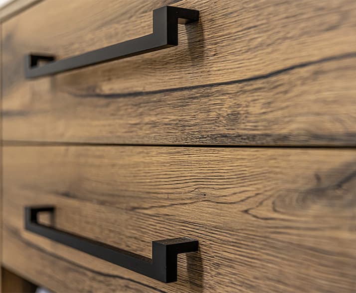 Detalle de mueble de madera con tiradores negros de Duok Carpinteros